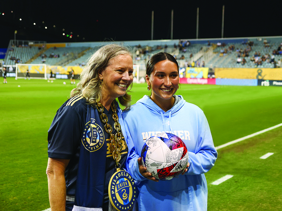 Widener President Stacey Robertson and student Madison Forte stand on the field at the Philadelphia Union