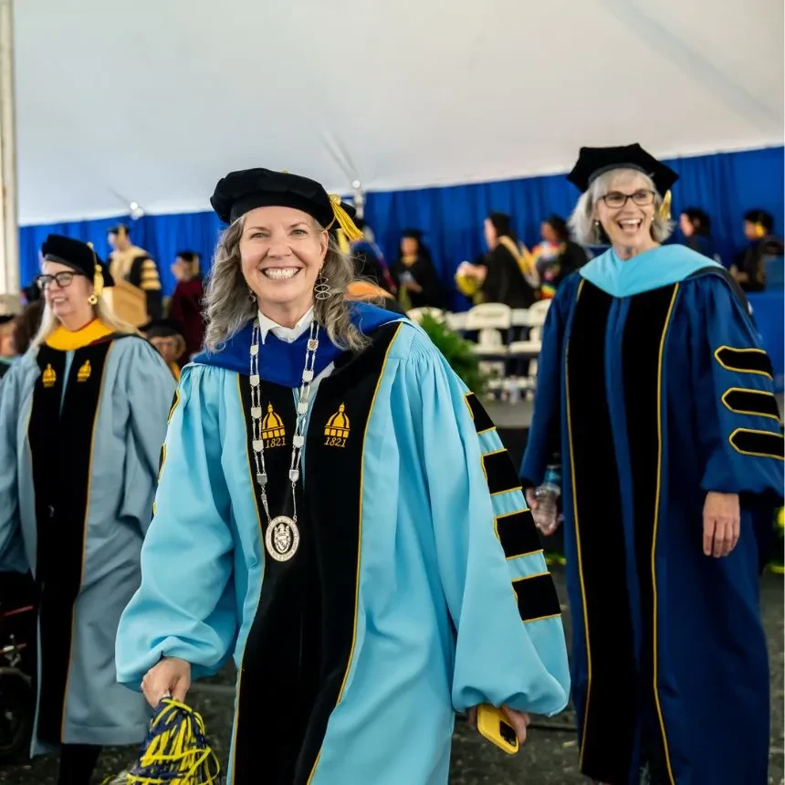 President Stacey Robertson and Associate Dean Jill Black smile as they recess out of commencement.