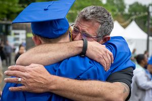 Widener parent hugs student at commencement