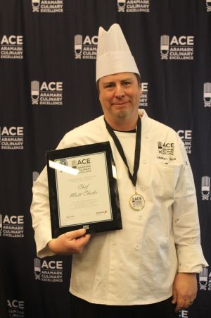 Widener Dining Executive Chef Matthew Clarke in his fine cooking uniform holding his winning plaque.