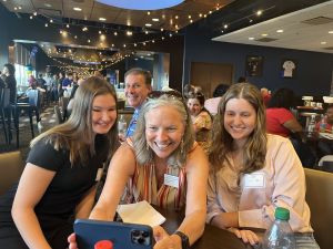 President Stacey Robertson takes a selfie with her cell phone, flanked by two students.