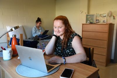 Students in a residence hall room working on laptops