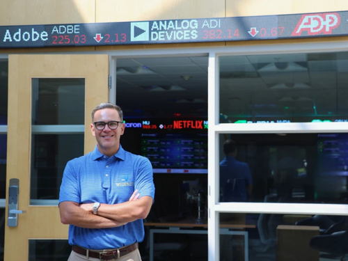 Cary Caro poses in front of the university's finance lab